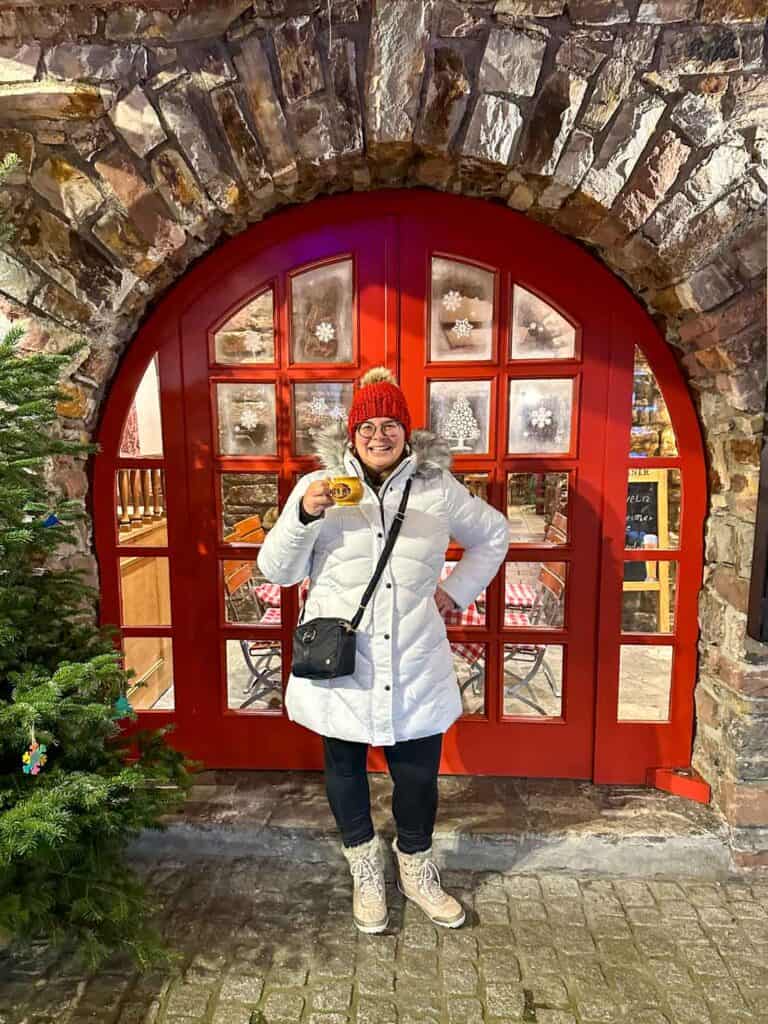 Amanda in a white winter coat with a Christmas market mug in Rudesheim, Germany