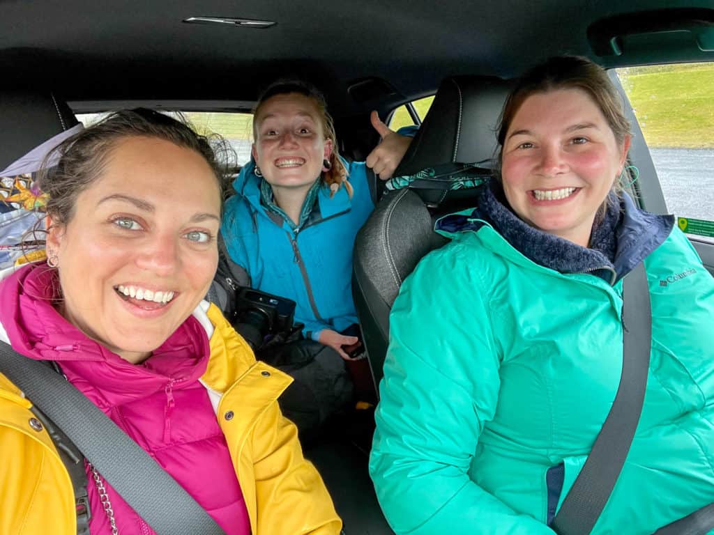Picking up hitchhikers in Iceland (three women in bright rain coats sitting in a car)