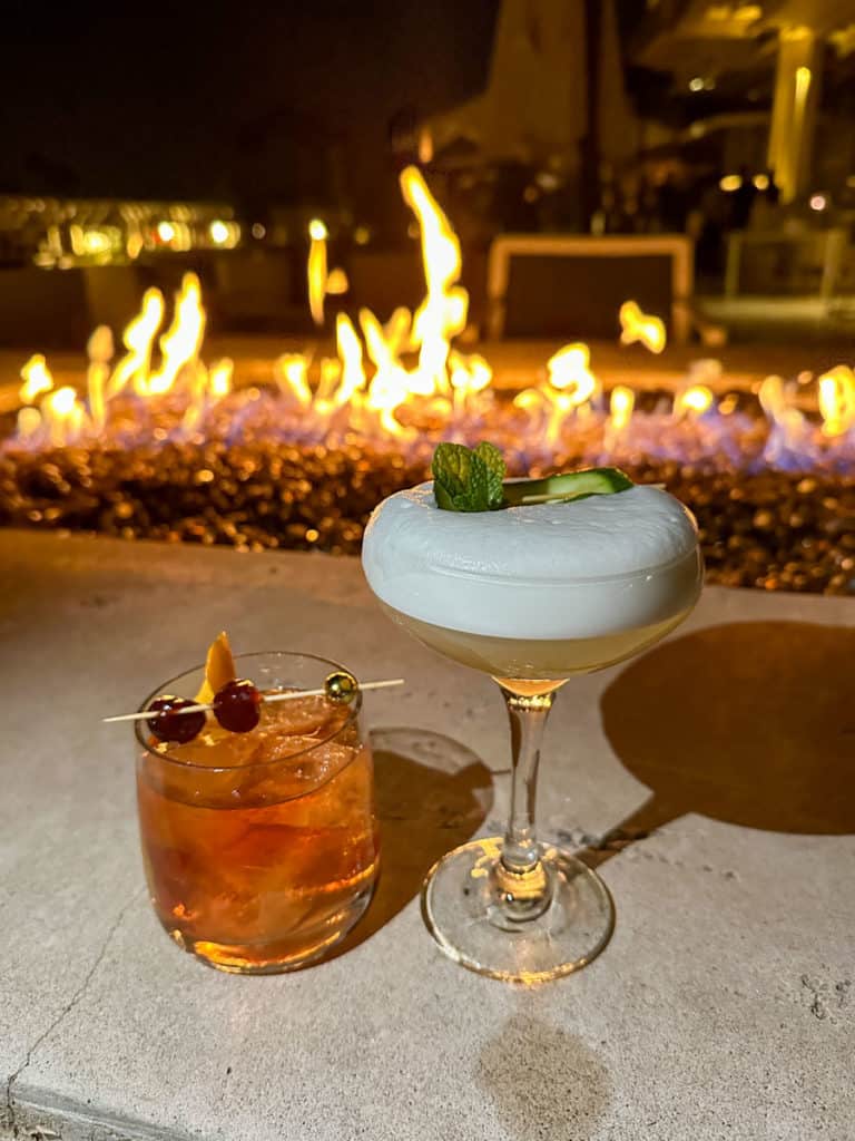 Cocktails in front of a fire pit at The Thirsty Camel