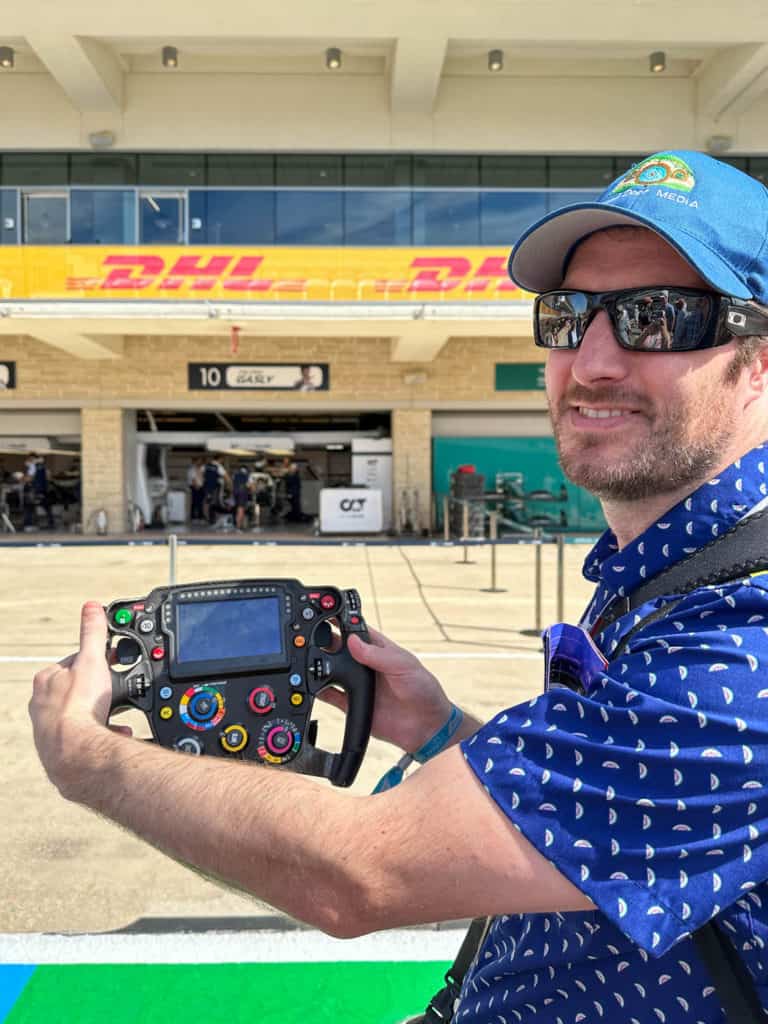 Elliot holding an F1 steering wheel