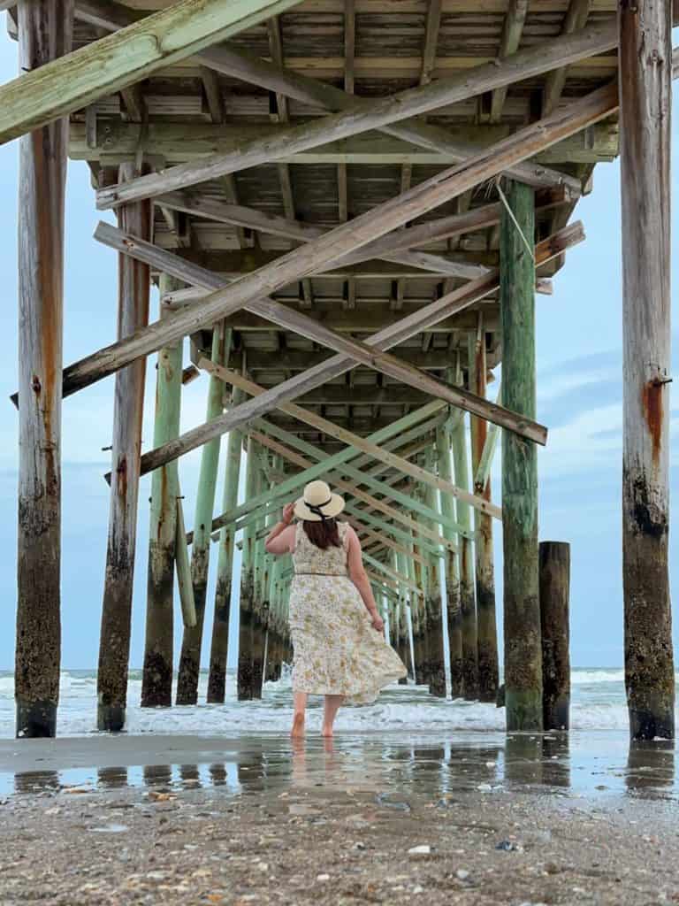 Amanda under a pier on the beach