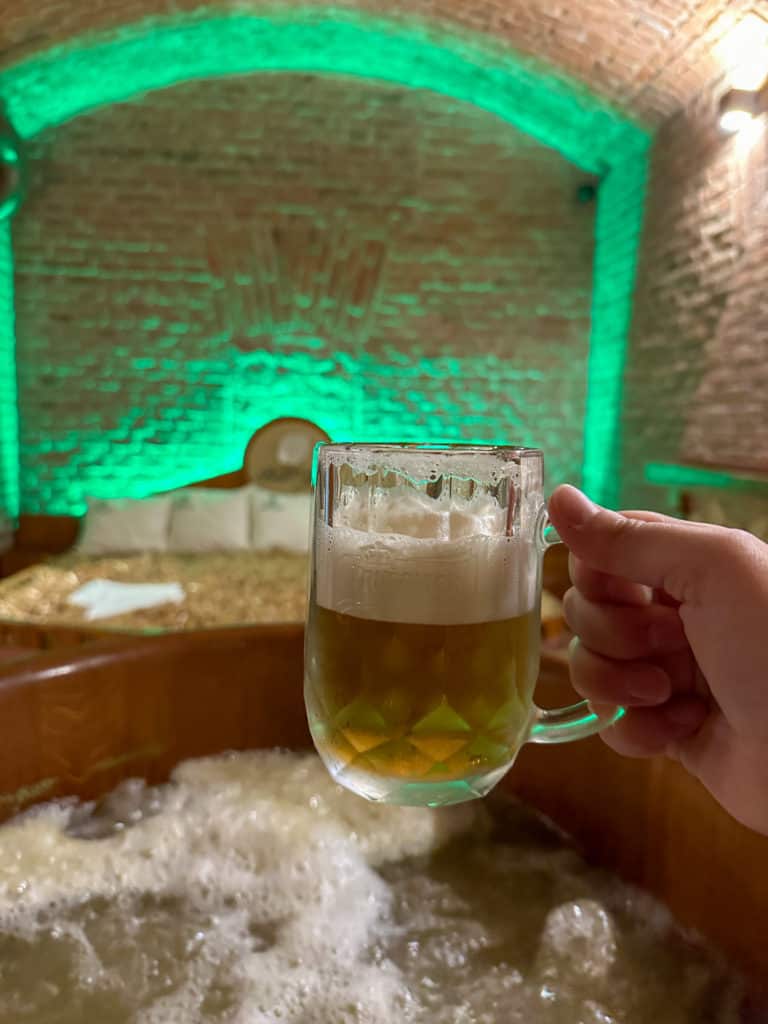 Small mug of beer held while in a beer hot tub