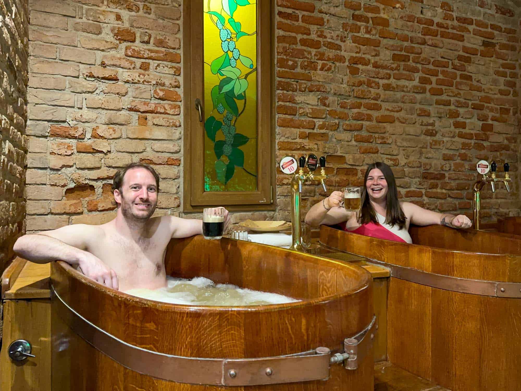 Amanda and Elliot in hot tubs at a beer spa